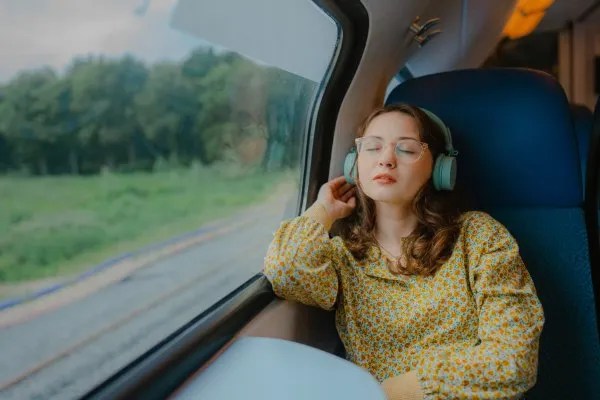 Mujer en un tren relajada con audifonos